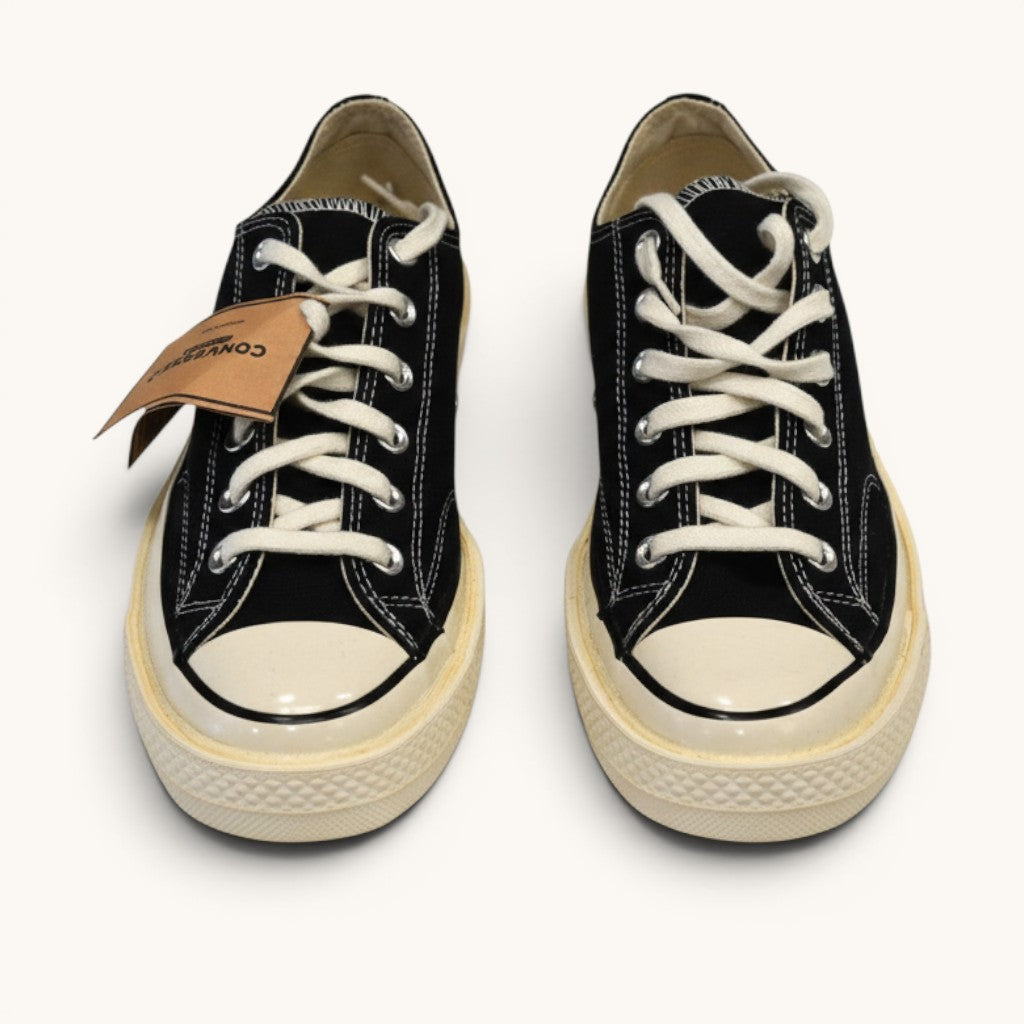 Numero 5 black canvas low-top Converse sneakers with white laces and cream rubber toe cap and sole.