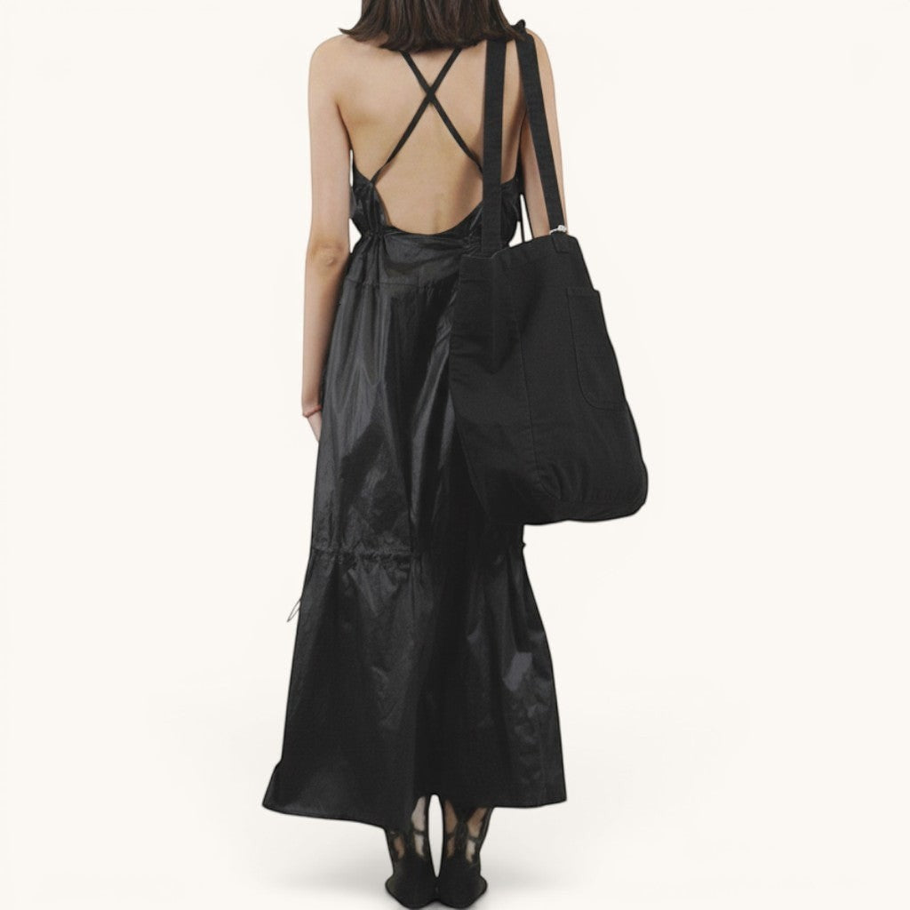Numero 5 black polyester parachute dress with adjustable waist, pockets, and criss-cross back straps.