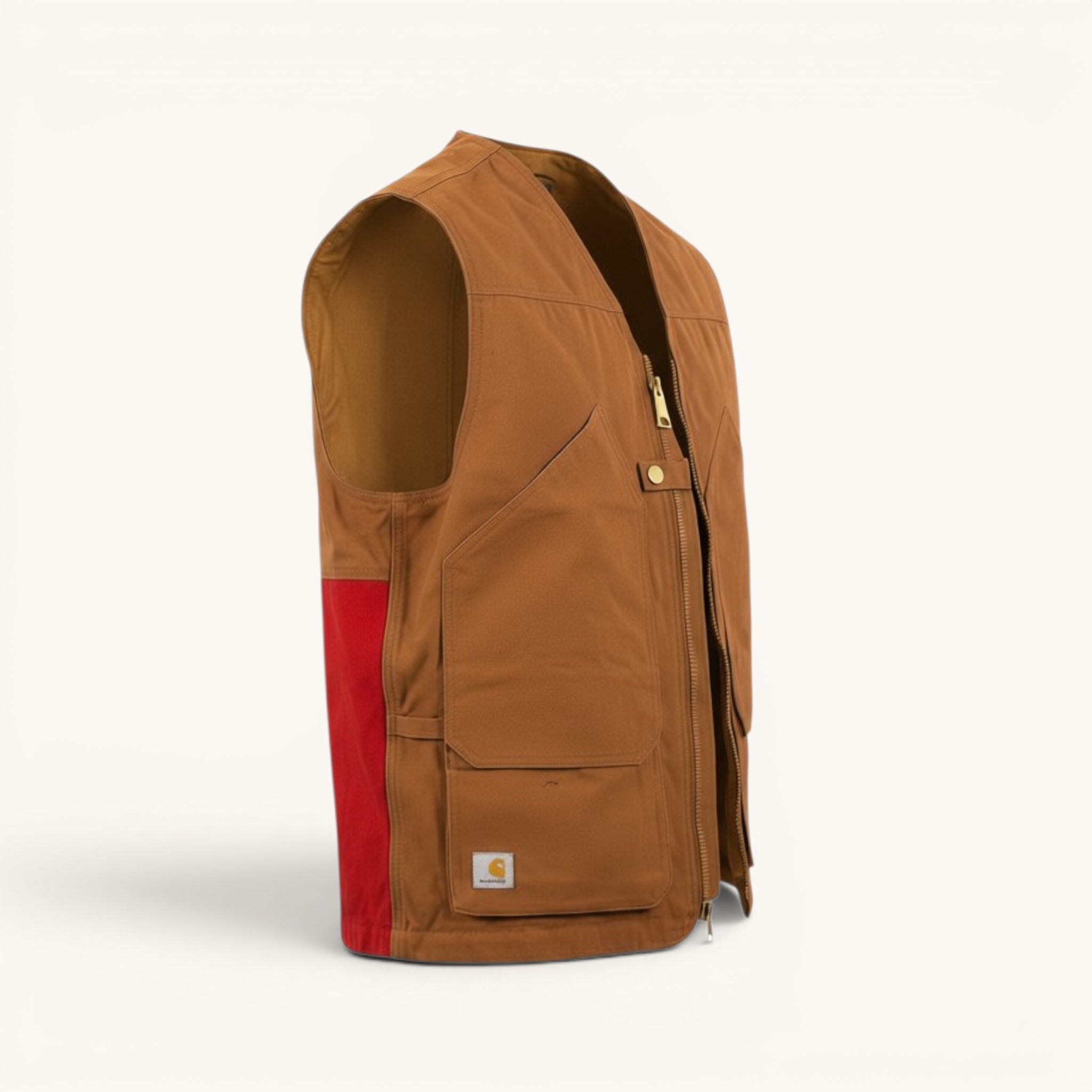 Numero 5 Gilet Carhartt marrone in tela con pannello laterale rosso, zip frontale e tasche multiple.