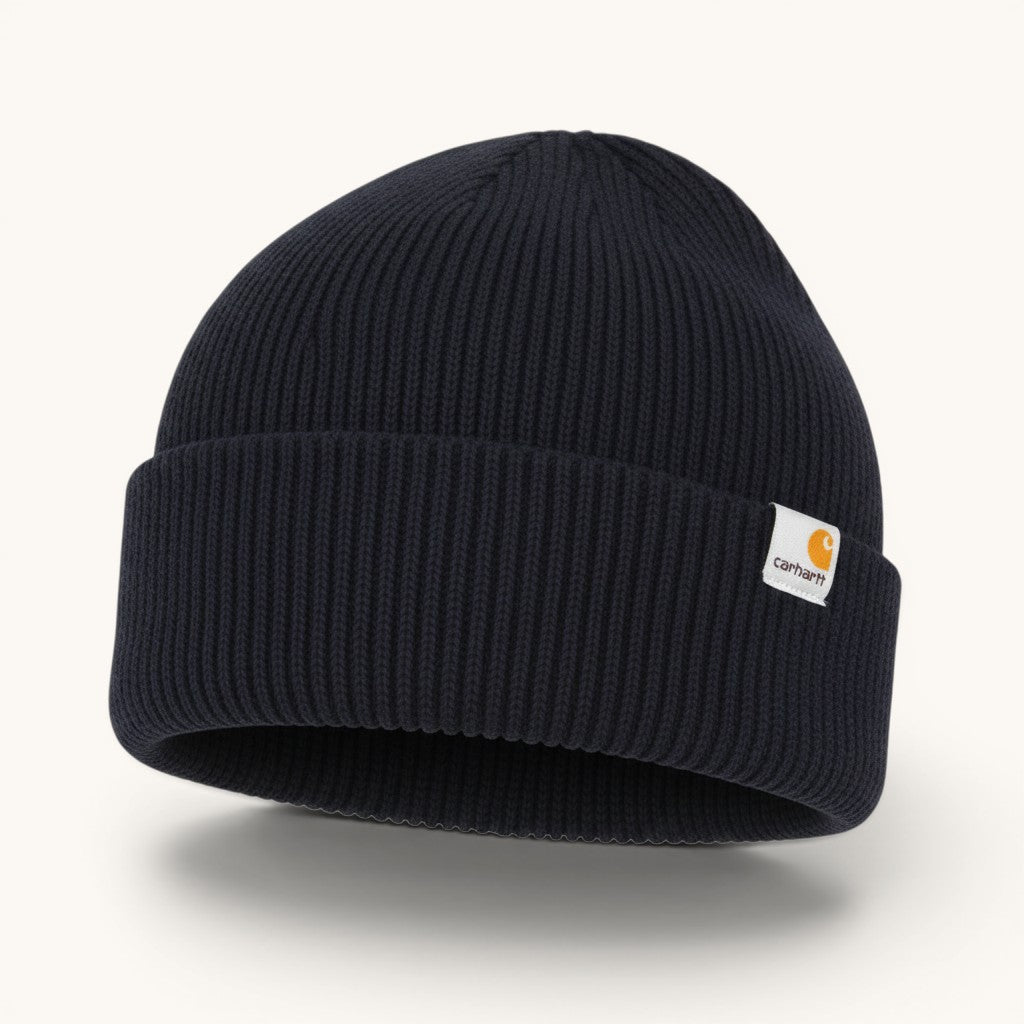 Numero 5: Dark navy blue ribbed knit Carhartt WIP beanie with a white label featuring the Carhartt logo.