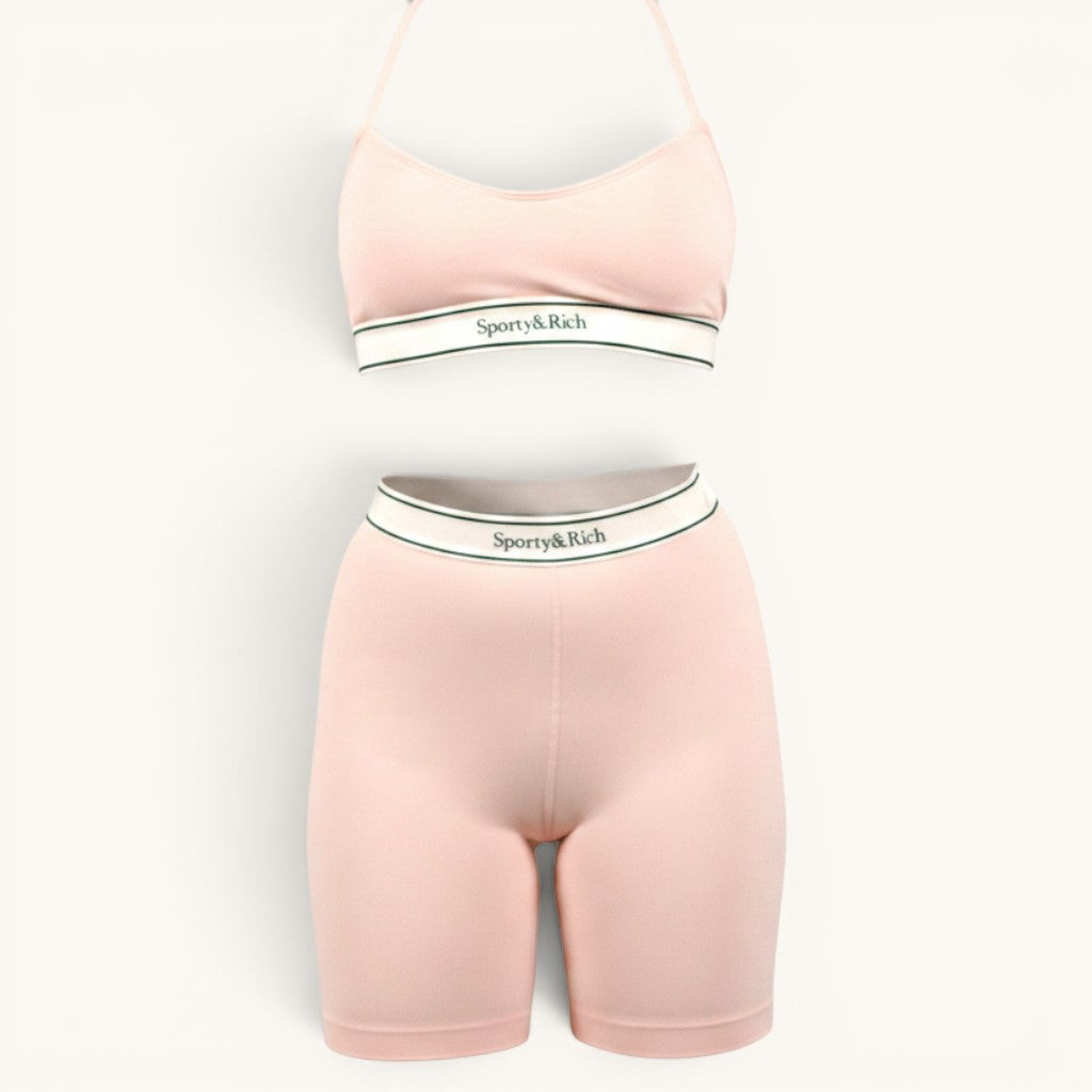 Numero 5 pink nylon-spandex sports bra and biker shorts set with white elastic band and green trim.