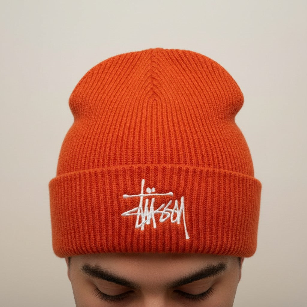 Numero 5 Stussy orange ribbed beanie with white embroidered logo. Streetwear style, one size fits all.
