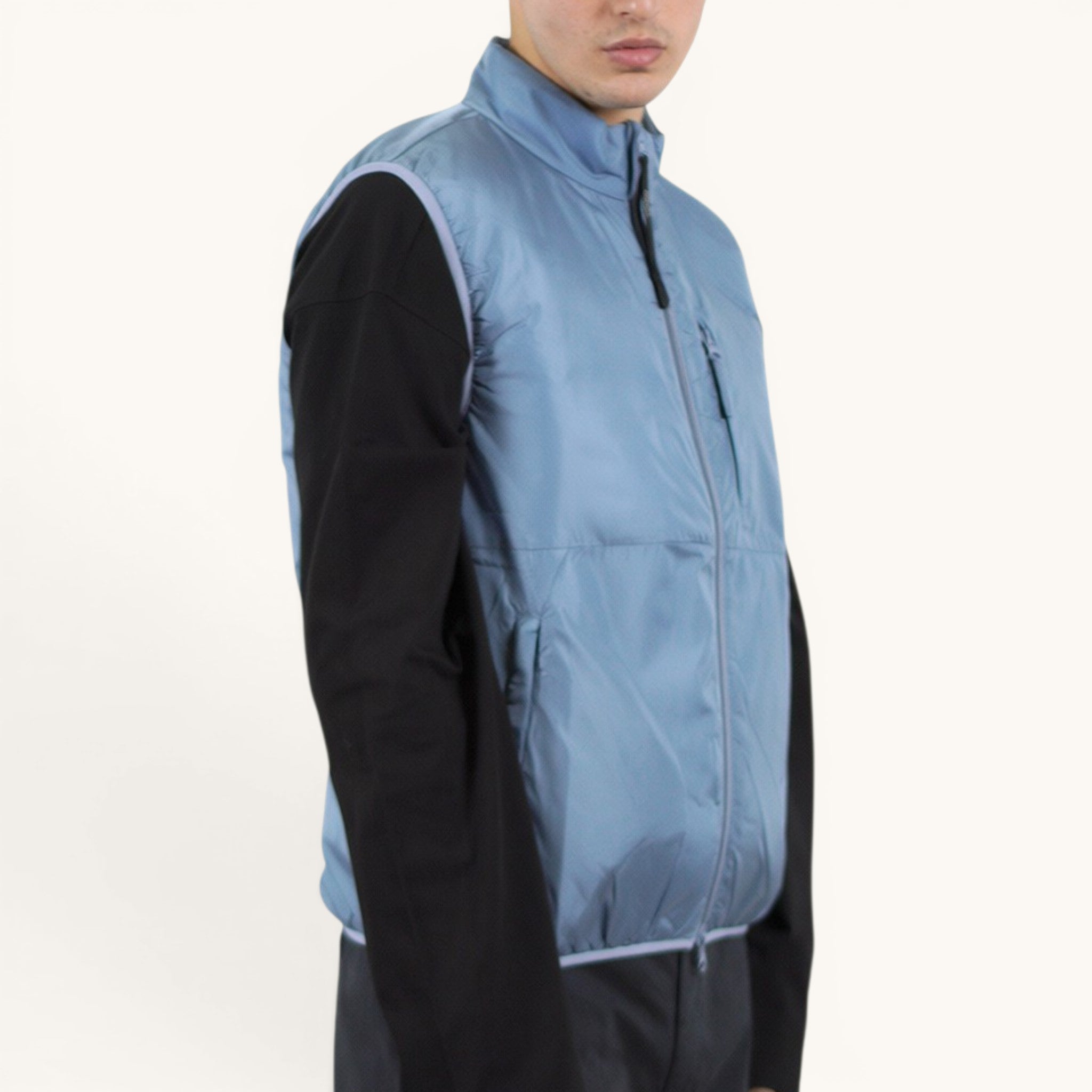 Numero 5 Aspesi light blue quilted vest with zip closure and pockets, worn over a black long-sleeved shirt.